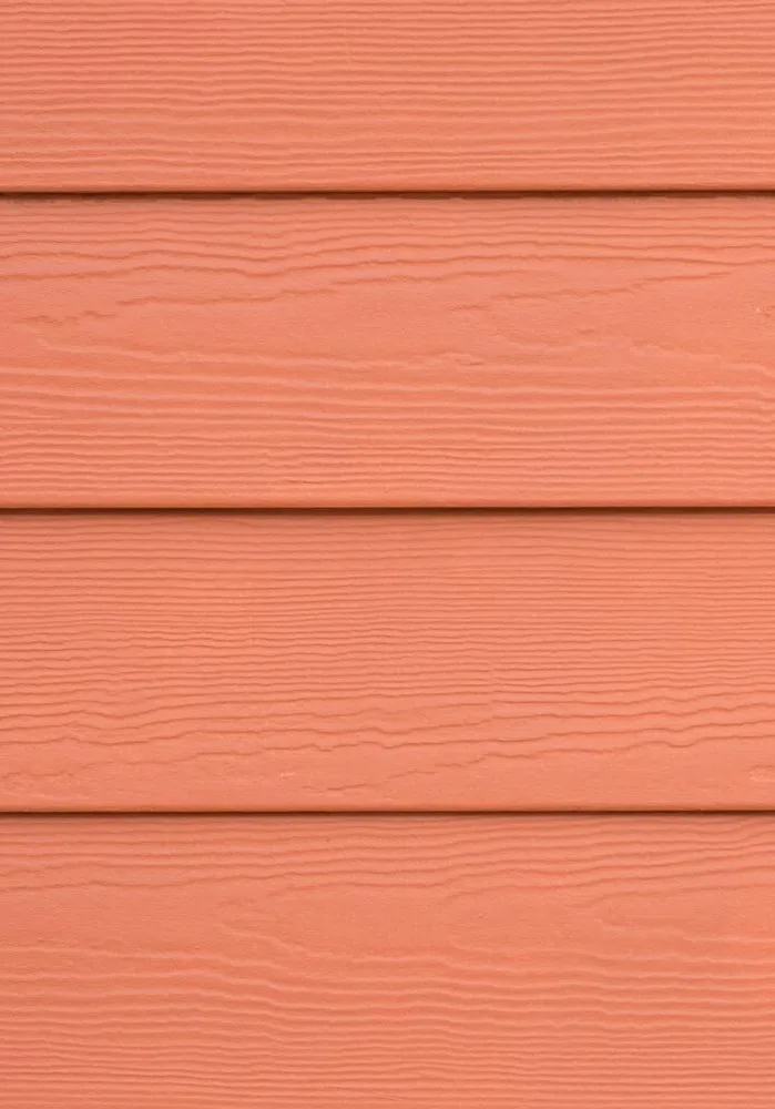 A close-up of orange fiber cement siding.