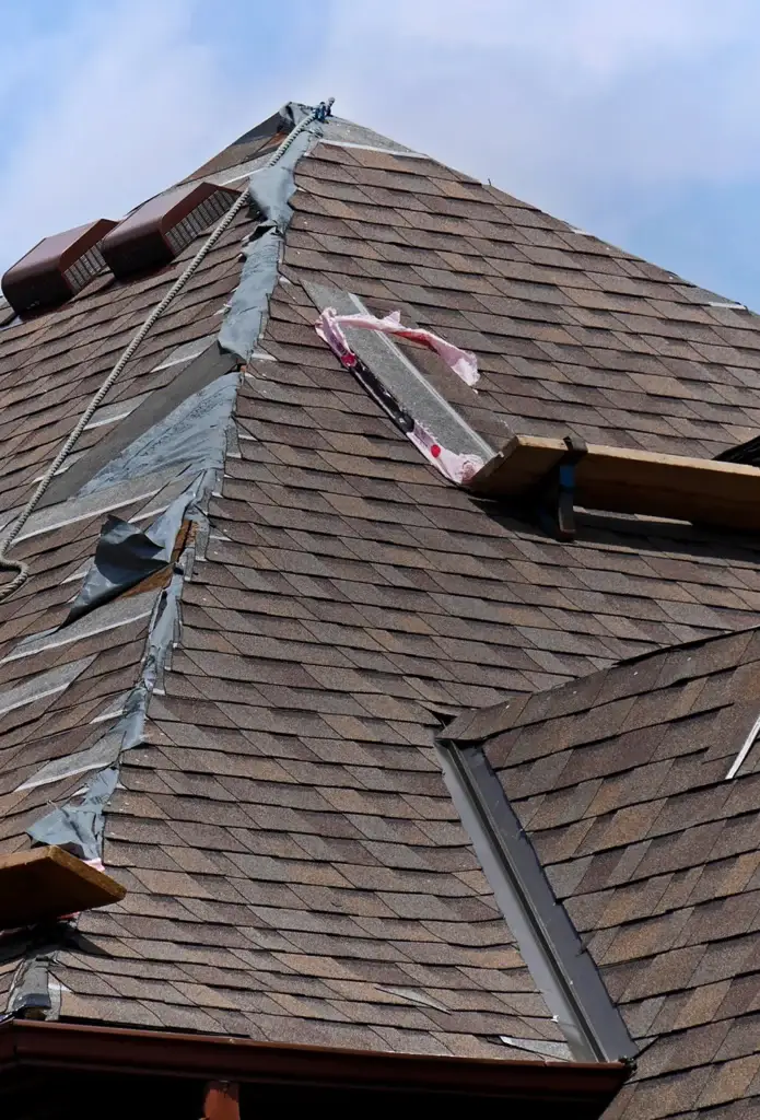 A damaged roof with shingles in need of repair, posing a potential risk to the house integrity.