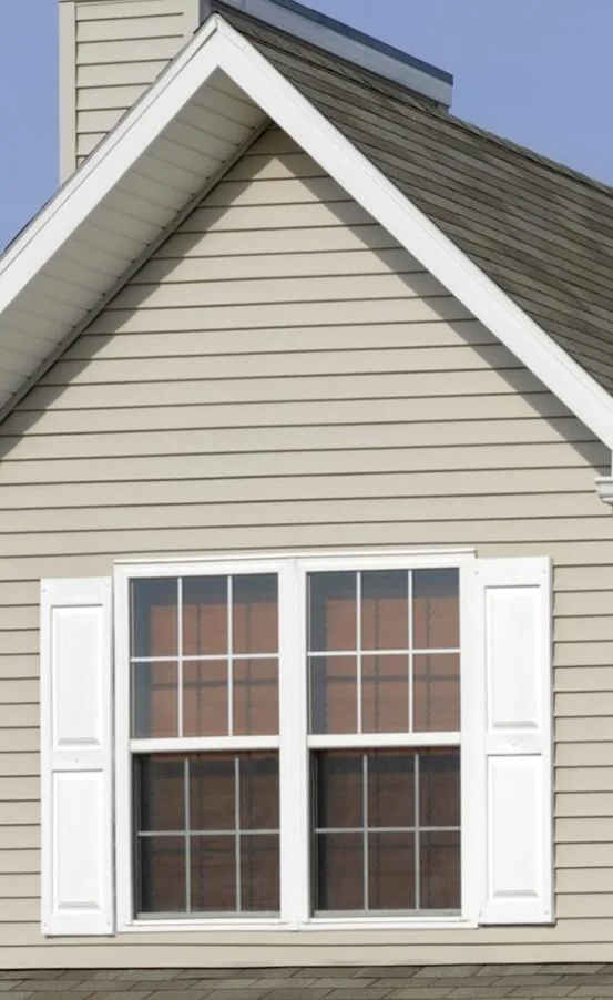 A residential house with a window view, featuring seamless gutters.