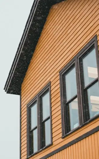 A house with orange siding and black windows.