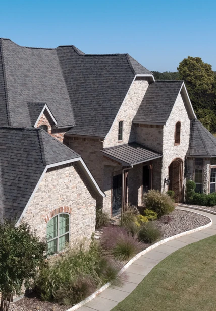 A spacious home with a roof view and a walkway leading up to it.